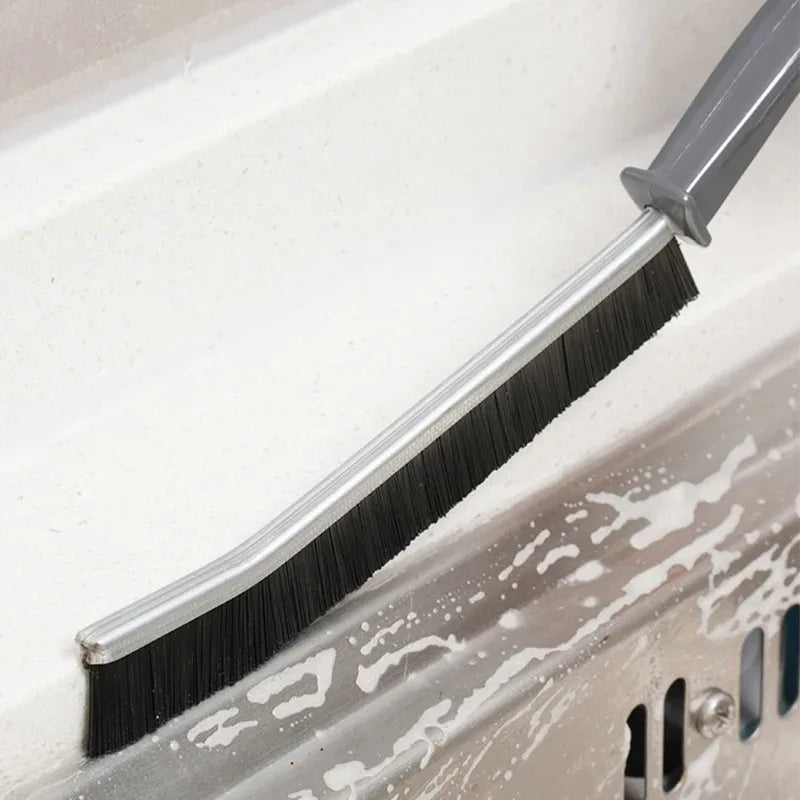 Manual grout brush cleaning a tile edge