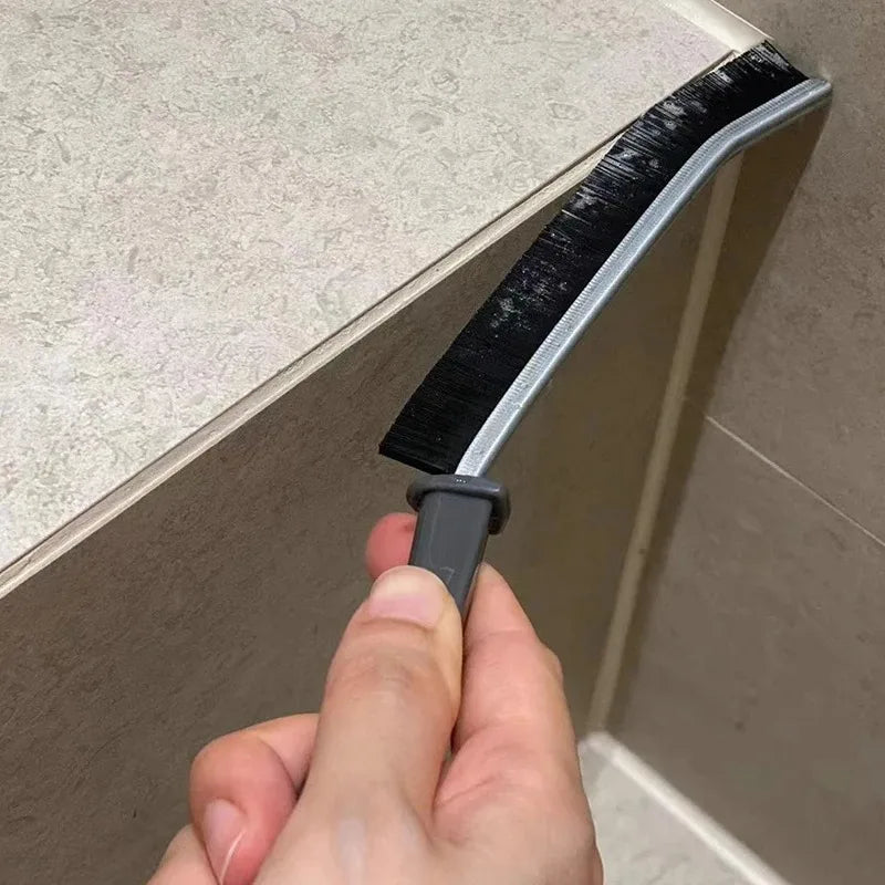 Manual grout brush tracing a tile joint