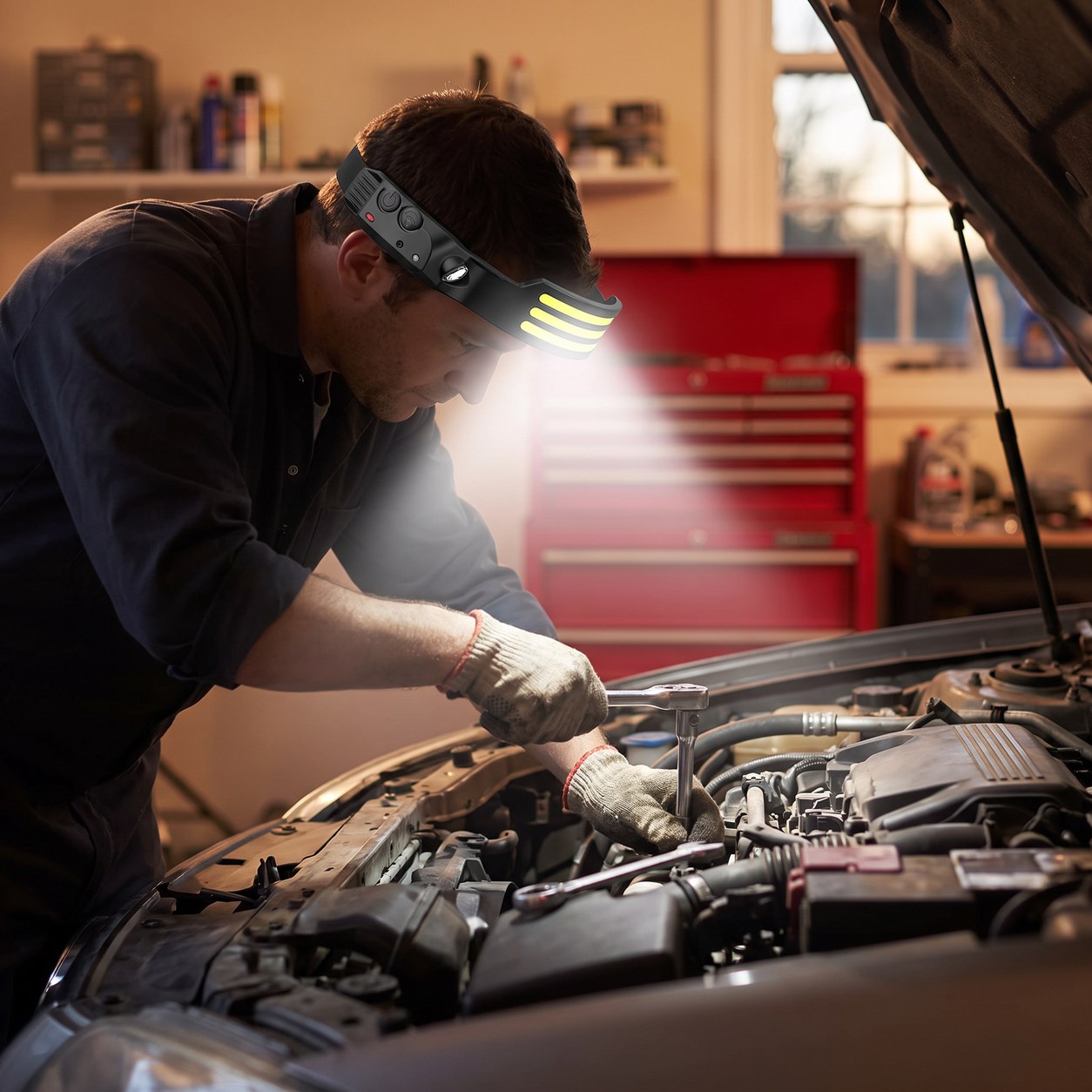 Mechanic wearing the rechargeable headlamp while working in an engine bay
