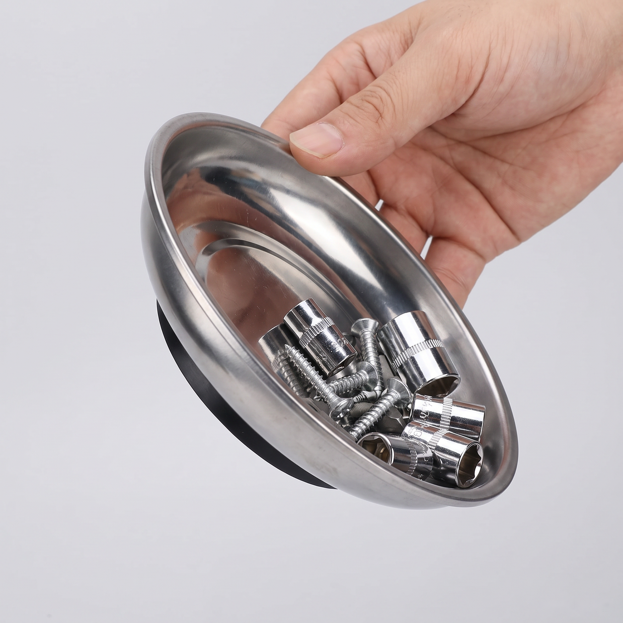 Hand tilting the magnetic parts tray while steel parts stay inside