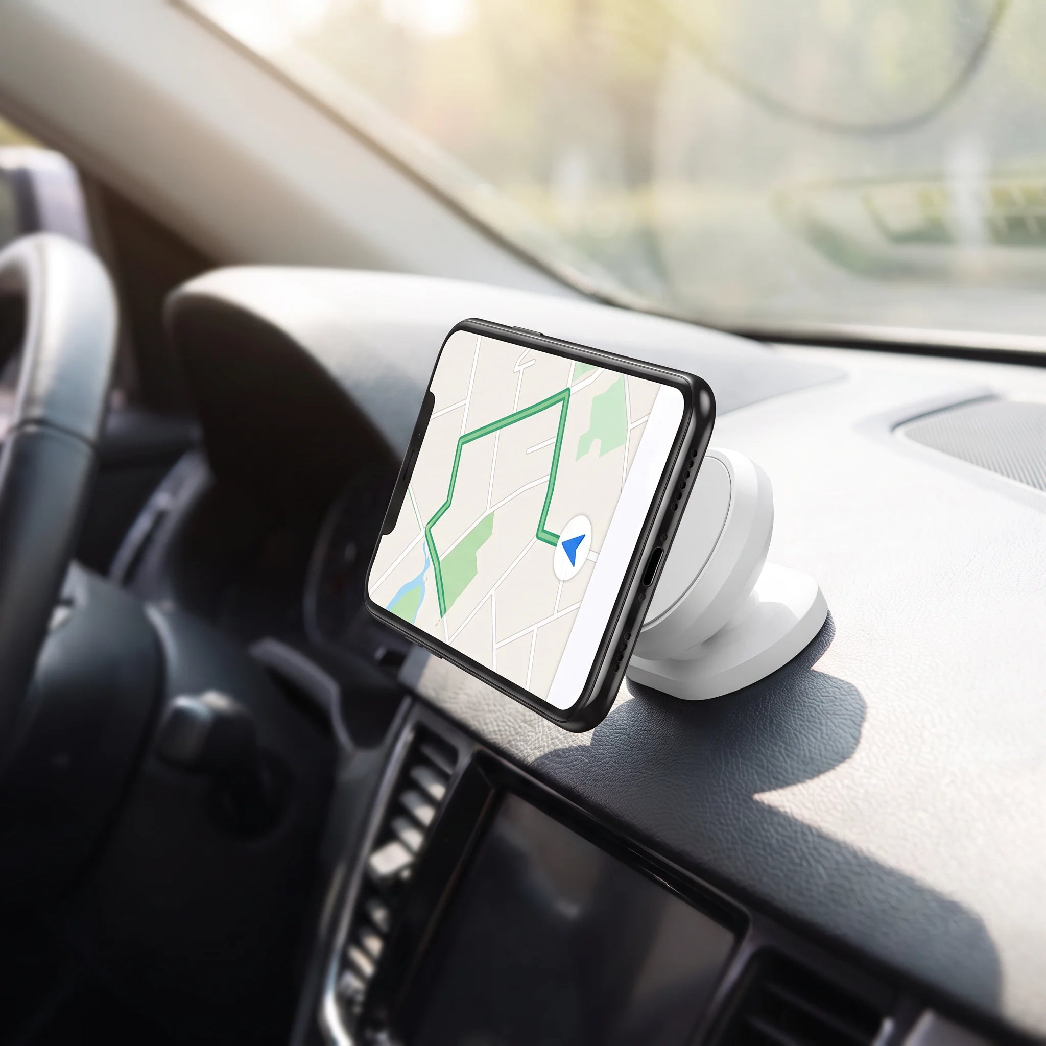 Phone held in landscape on a white magnetic mount on a car dashboard