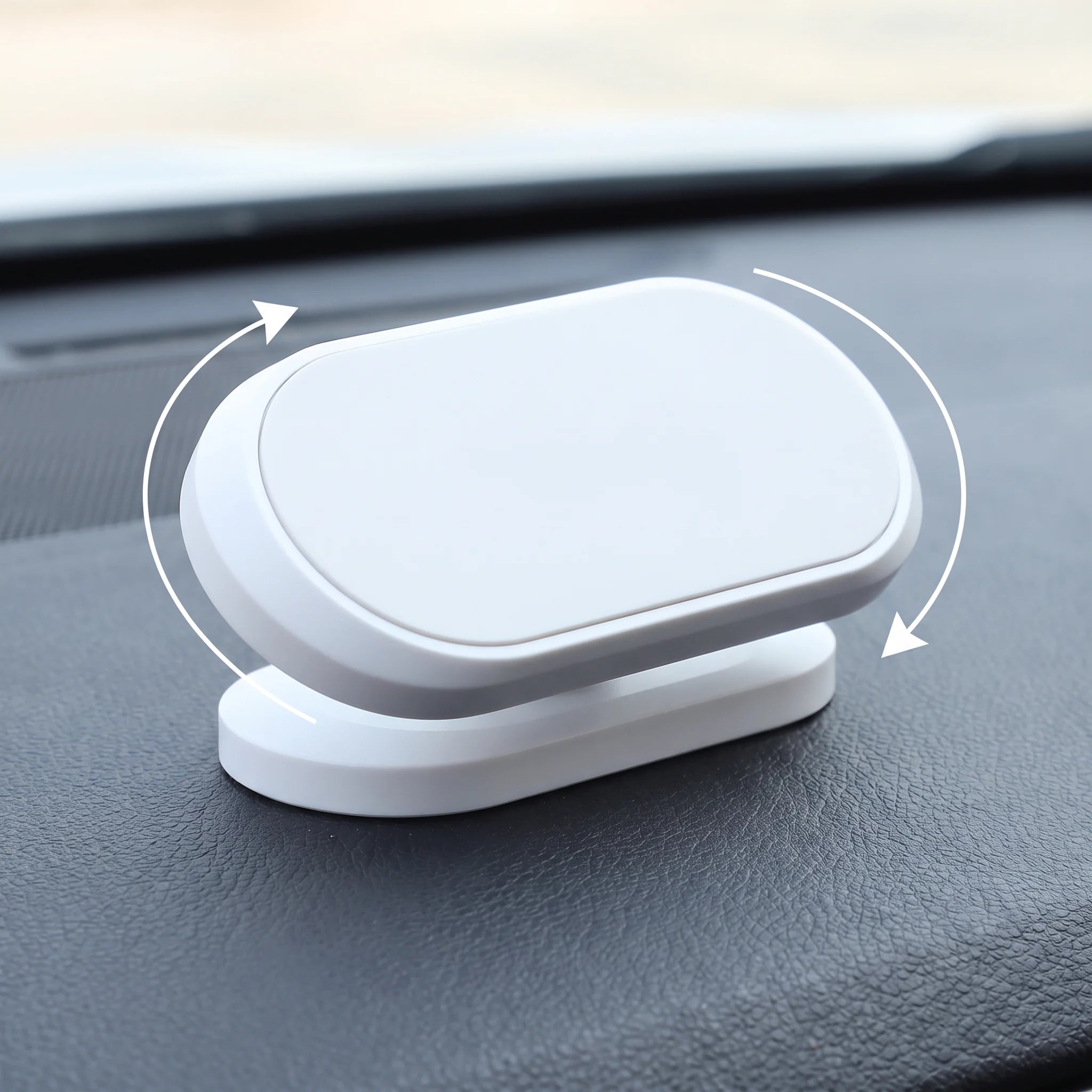 White magnetic phone mount head swivelling on a car dashboard